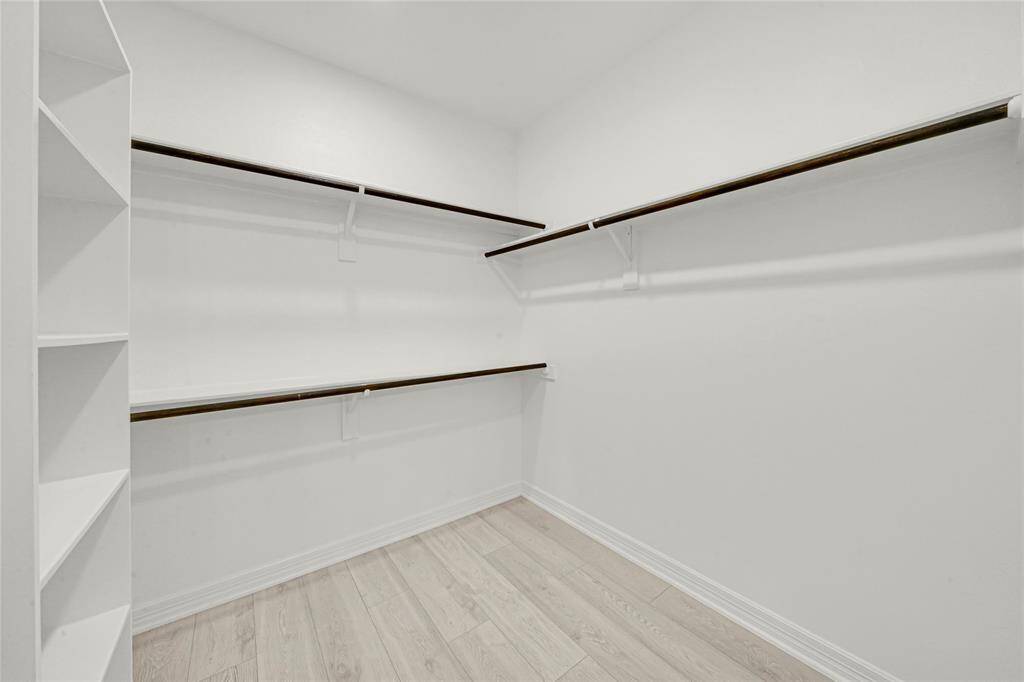 Generously sized walk-in closet with built-in shelving.