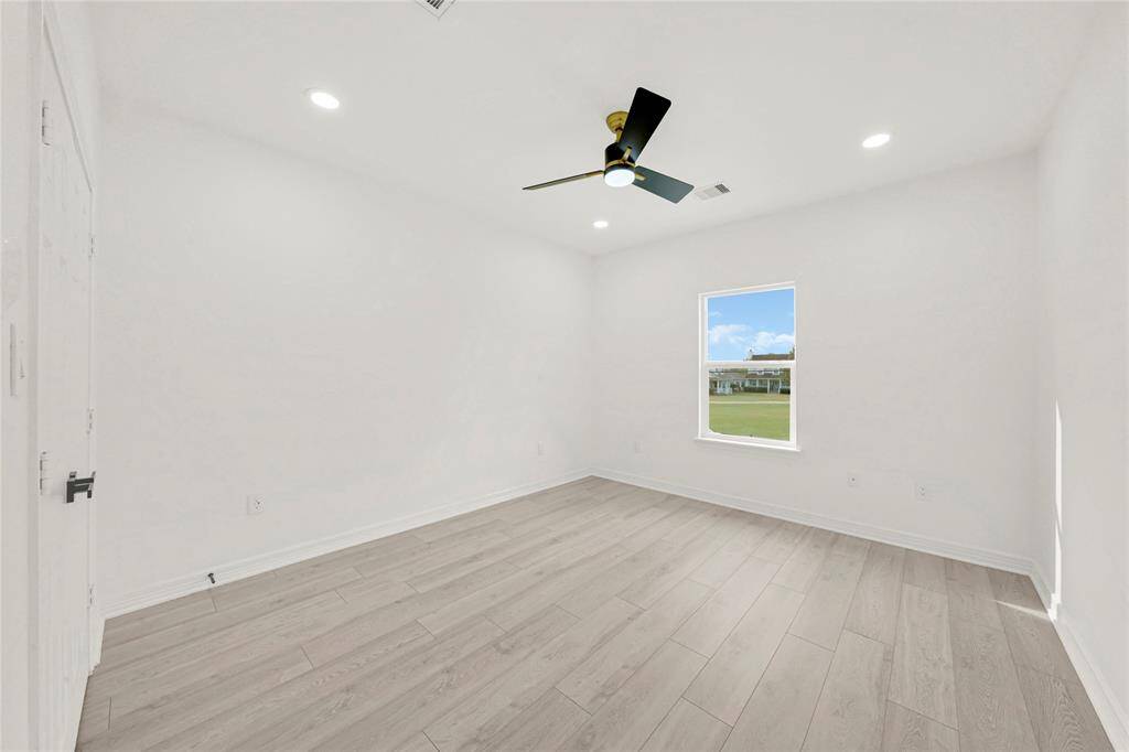 Secondary bedroom with neutral tones, ceiling fan, and walk-in closet.