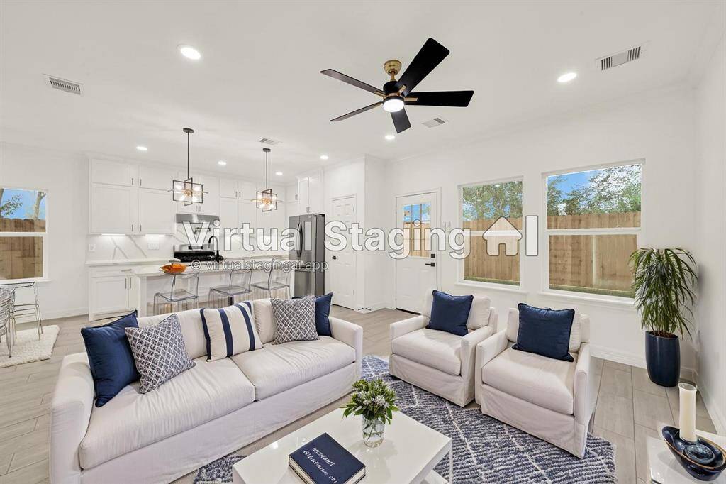 Spacious and airy living room with soaring ceilings, ceiling fan, and abundant natural light.