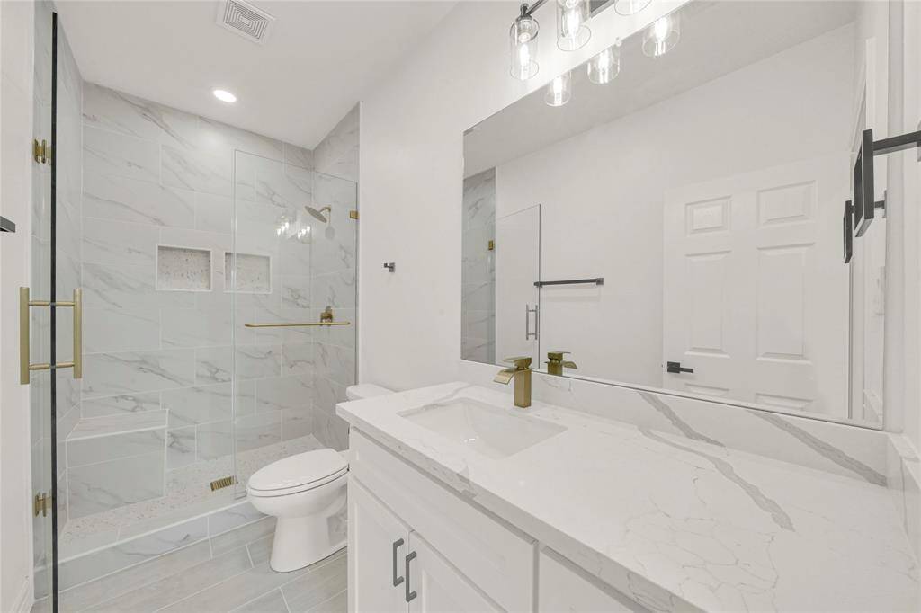 Full bathroom with contemporary finishes and walk-in shower.