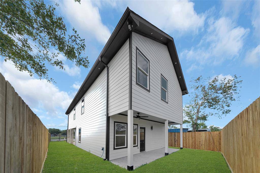Side view showcasing exterior materials, privacy fence, and modern architecture.