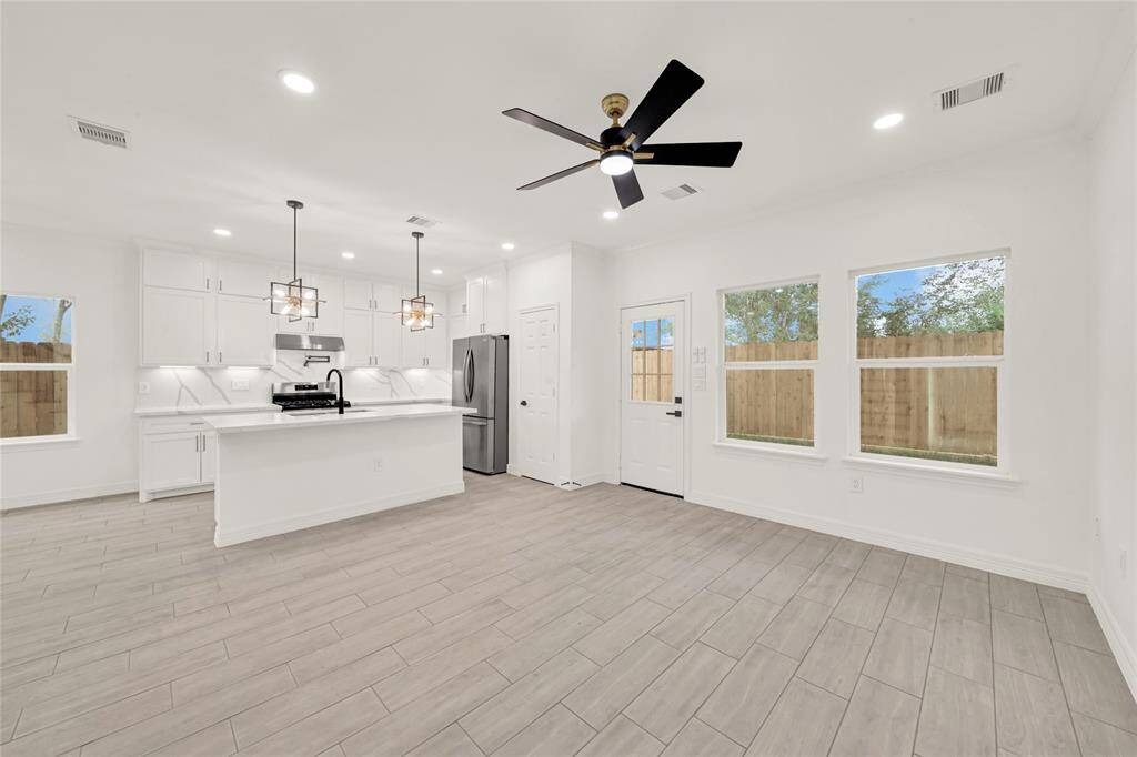 Seamless open-concept layout blending living and dining areas with luxury vinyl plank flooring.