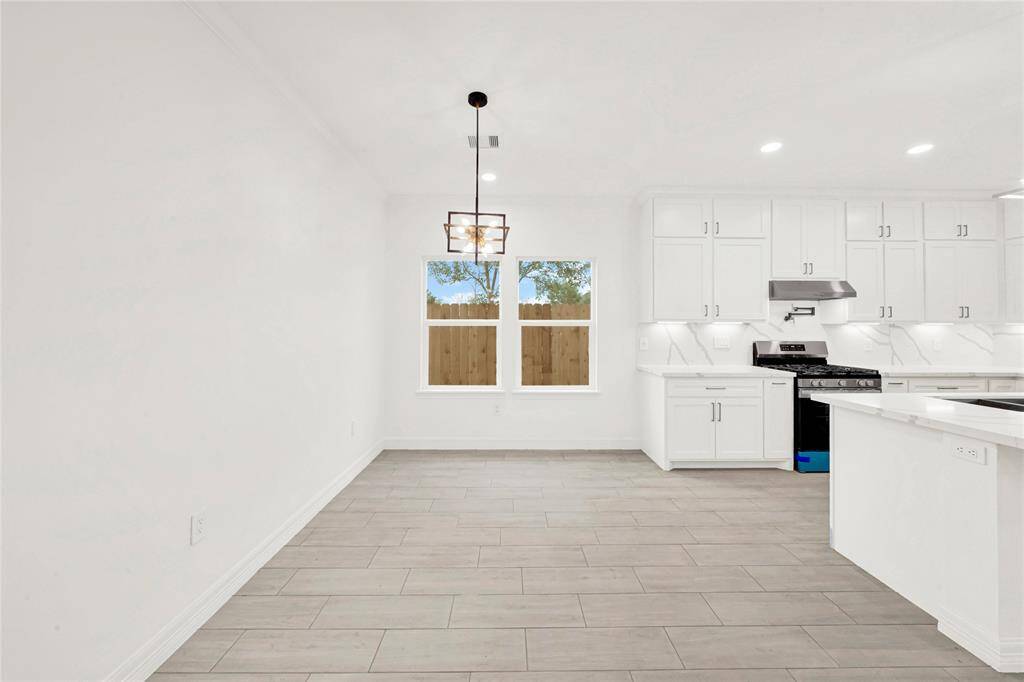 Modern kitchen with island seating, open flow to dining, and elegant pendant lighting.