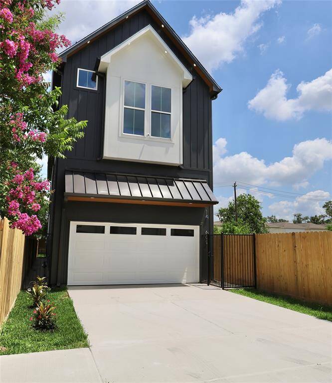Private wide driveway lined with vibrant flowers and plants; enter through your secured metal gate.