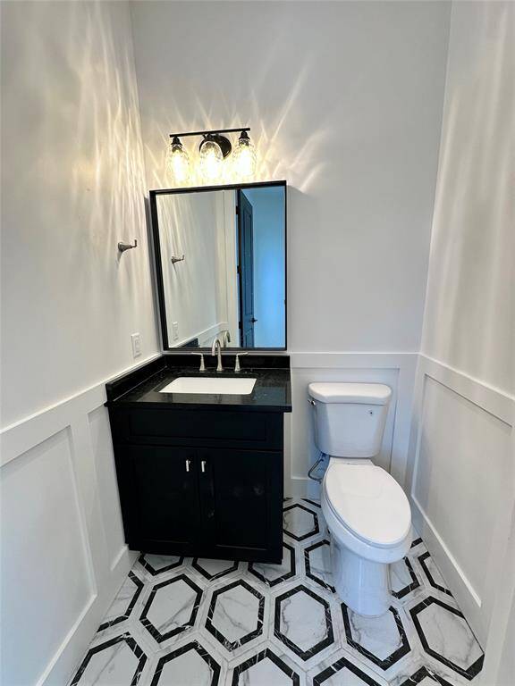 Chic powder room with wainscoting adding an additional flare.