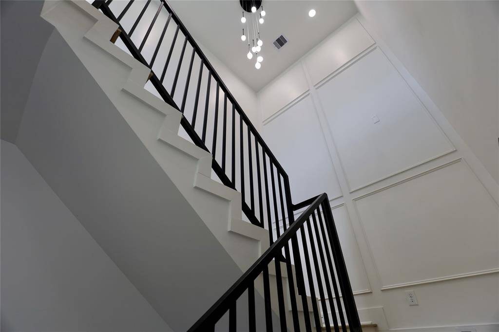 35 FT accent wall paired with a brilliant modern chandelier and metal rails