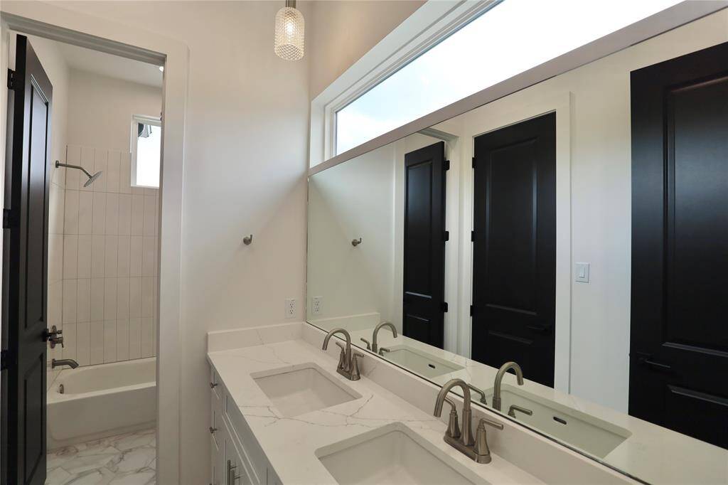Jack + Jill elegant second bathroom, featuring 2 sinks with designer faucets + custom sized mirror.
