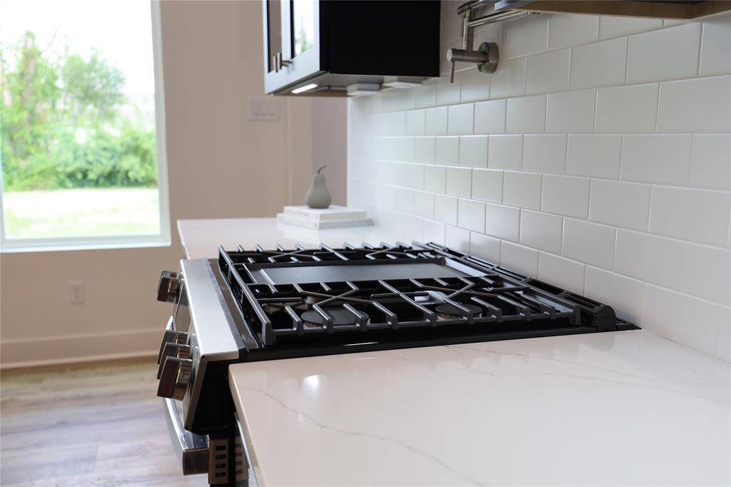 GE gas range with a centered griddle, oven offers a built-in air fryer, and a pot filler above — where power meets ease, and every meal begins like magic.