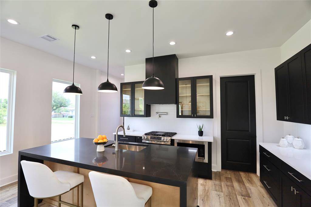Ample natural light brightens the kitchen space, the glass cabinets  allow to showcase your cherished dish-ware or coffee cup collection.