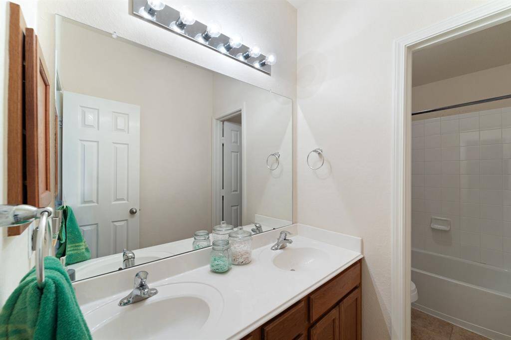 Full upstairs bathroom with dual sinks, plenty of counter space, and a private tub/shower combination.