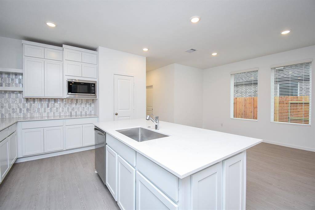 Enjoy a modern kitchen layout with a conveniently separated microwave and stove for enhanced functionality.