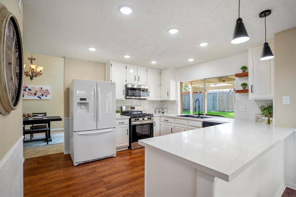Looking back across the kitchen toward the breakfast nook, the doorway to the formal dining room is just to the left, highlighting the seamless flow between these inviting spaces.