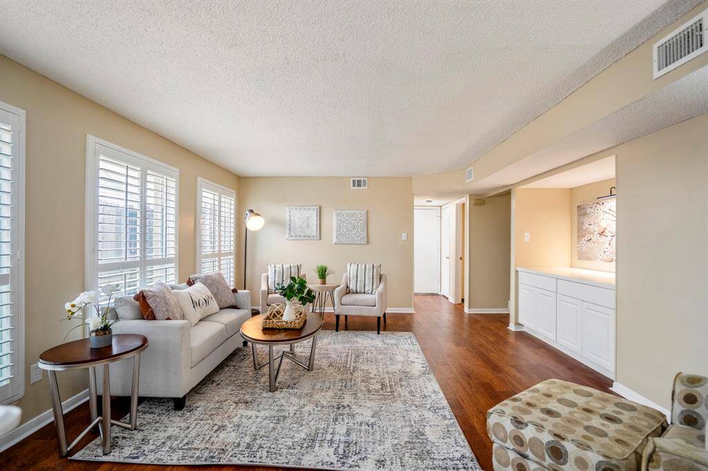 Stepping into the family room, notice the recessed dry bar with quartz countertop to the right. Straight ahead, a short hallway leads to the laundry room on the left, a half bath on the right, and the garage entry in between. Just beyond the dry bar, an opening connects back to the formal living room and staircase.