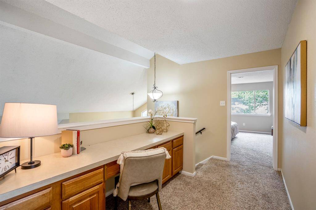 A closer look at the built-in desk in the study nook, where light fills the space and you can catch a glimpse into the serene primary suite nearby.