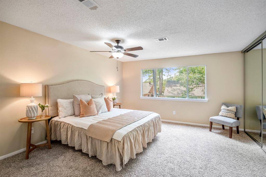 The spacious primary suite features large window overlooking the backyard and mirrored sliding doors revealing one of two generous closets, offering both comfort and storage.