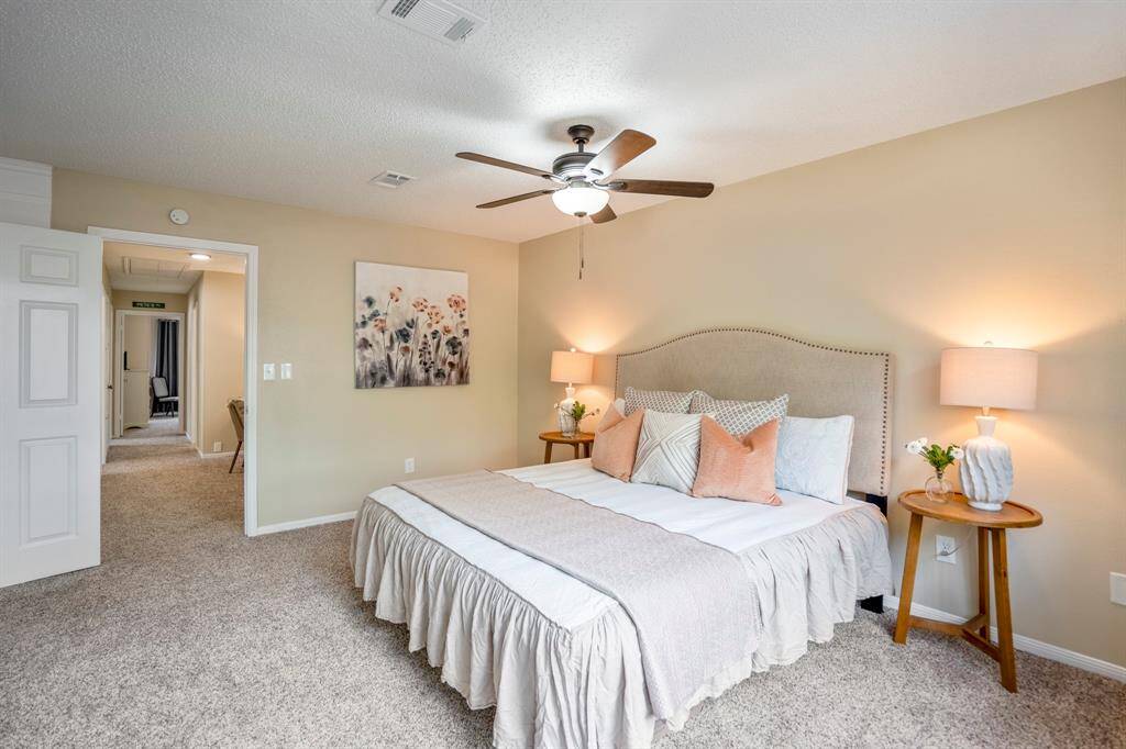 From near the primary bedroom window, take in the view back toward the doorway and hallway that leads to the additional bedrooms, creating a private and connected layout upstairs.