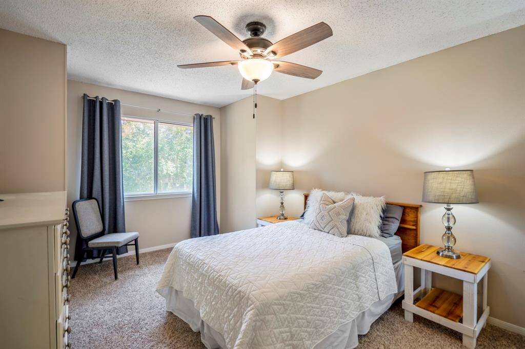 This secondary bedroom features a charming bump-out design and a large window that welcomes plenty of natural light while offering a view of the front yard, creating a bright and inviting space.