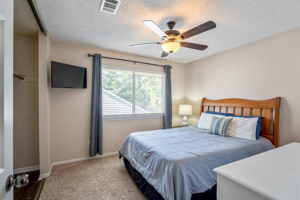 This spacious secondary bedroom boasts a large window that fills the room with natural light, creating a warm and comfortable retreat.