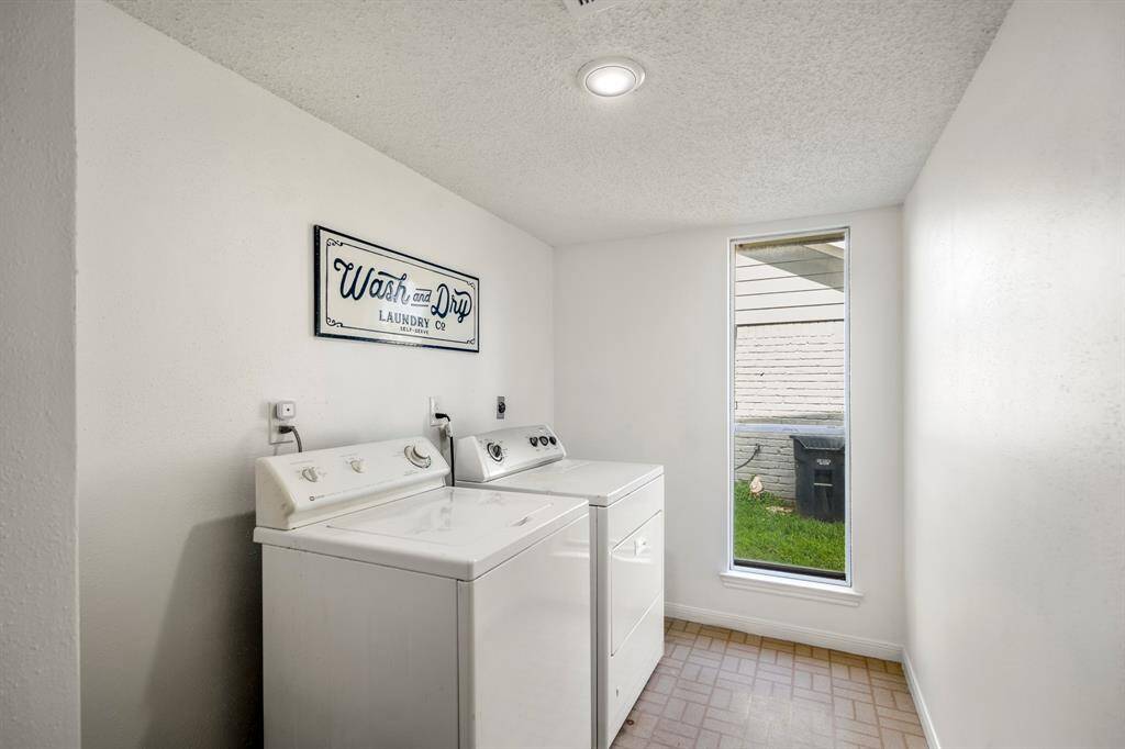 The spacious laundry room on the main level features a large window that fills the space with natural light, making chores more pleasant and efficient.