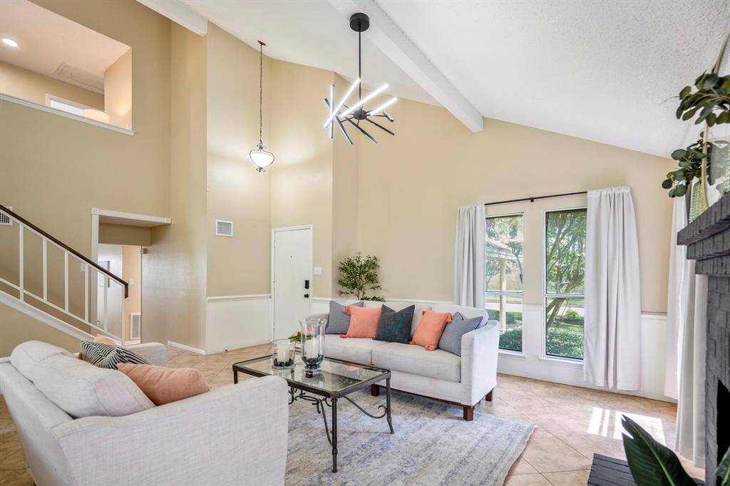 From the fireplace, look back toward the front entry to see how the layout flows—past the stairs and into the cozy, sunken family room. A glimpse of the upstairs study nook offers a peek into the thoughtful use of space throughout the home.