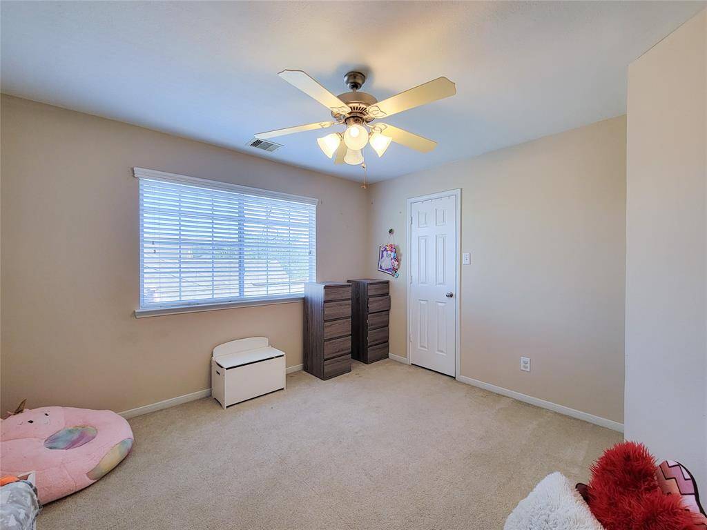 This spacious game room upstairs features neutral walls, two ceiling fans, making it perfect for relaxation and entertainment.
