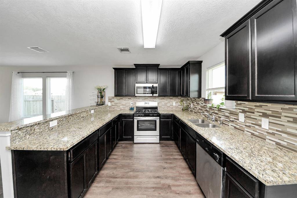 Indulge in culinary delights in this gourmet kitchen, where sleek granite countertops and elegant cabinetry create a seamless blend of style and functionality. The spacious dining area beckons you to savor meals with loved ones, surrounded by natural light streaming in through the large windows.