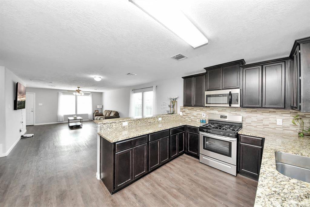 Indulge in culinary delights in this gourmet kitchen, where sleek granite countertops and elegant cabinetry create a seamless blend of style and functionality. The spacious dining area beckons you to savor meals with loved ones, surrounded by natural light streaming in through the large windows.