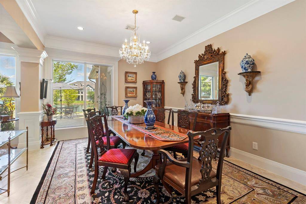 Elegant dining room adjoins the elegant living room and is also flanked with large windows offering natural light and views of the outdoor patio and lake.