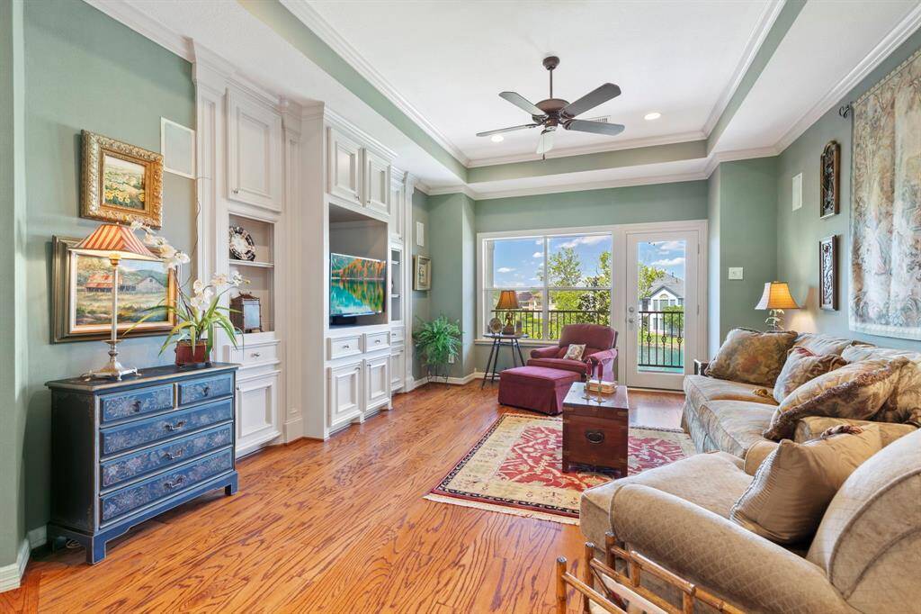 This additional, upstairs, family room features elegant hardwood floors, a cozy seating area, and built-in cabinetry. Large windows and a glass door lead to a balcony, offering plenty of natural light and a pleasant view of the back yard and the lake. This space is a peaceful haven.