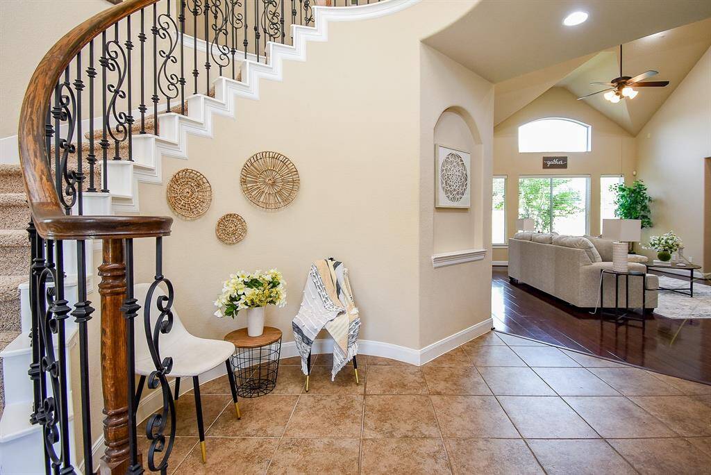 From the entry, the home invites you deeper into the layout, with the living area unfolding just beyond the staircase—offering a preview of the open, interconnected spaces ahead.