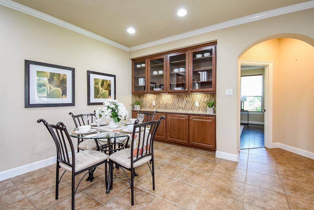 Set beside the kitchen, this breakfast corner is well-lit and enhanced by custom upper glass cabinets with built-in lighting, creating a café-like atmosphere.