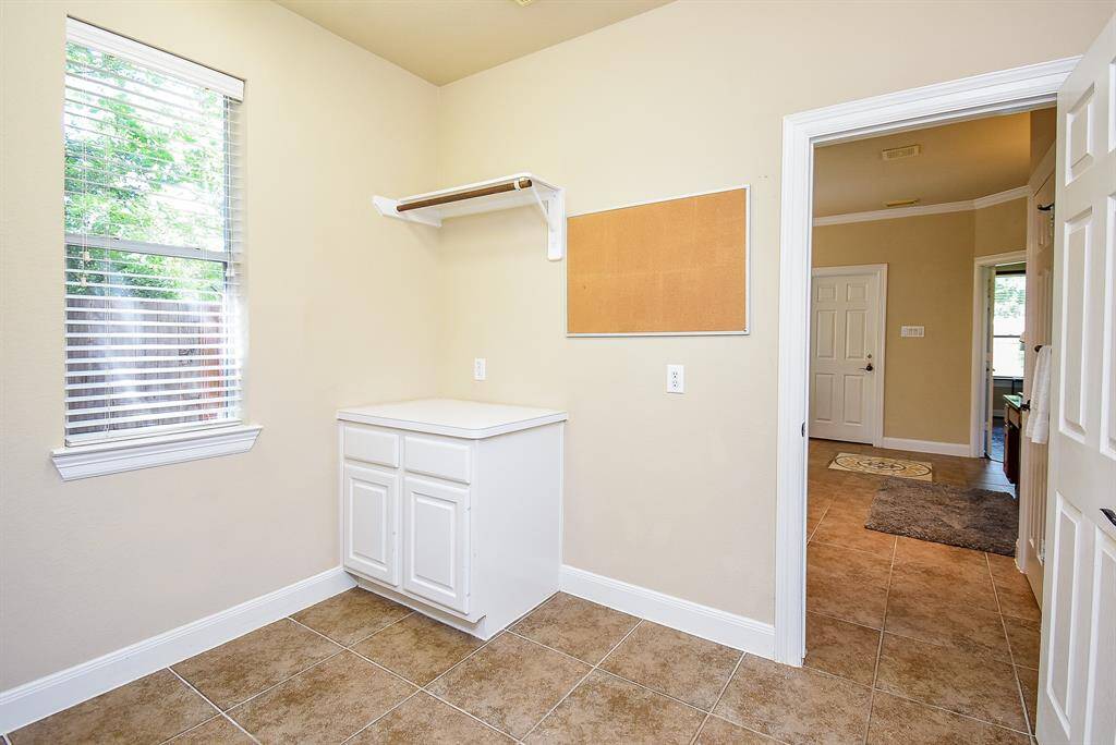 Spacious and well-planned, the laundry room includes countertop workspace, overhead shelving, and room to maneuver—making everyday chores feel a little less routine.