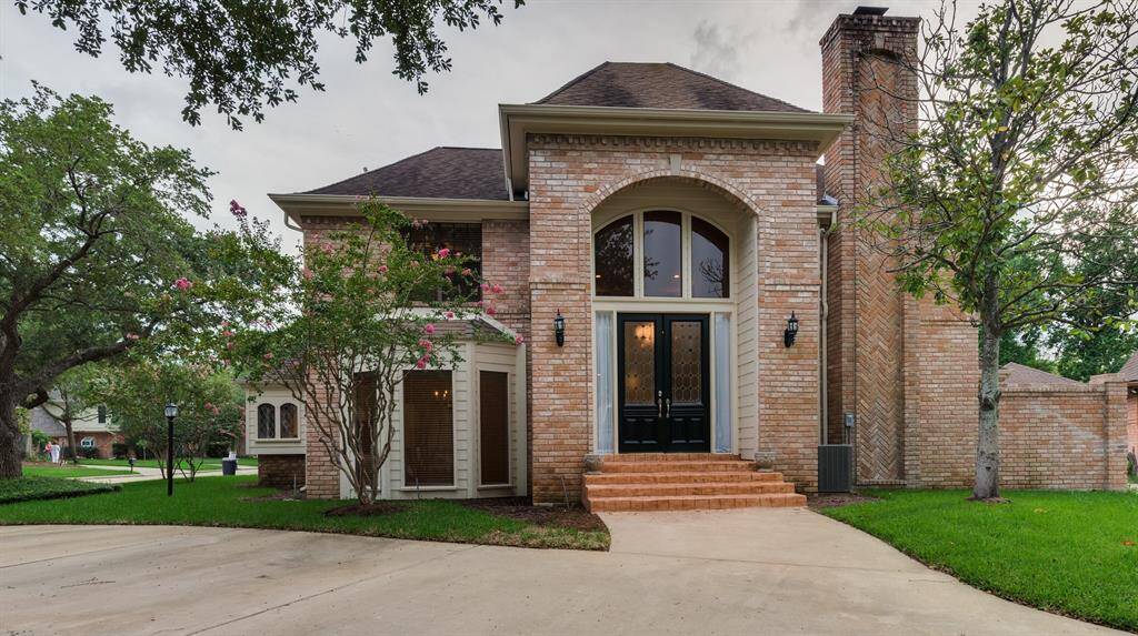 Stunning curb appeal with a classic brick façade, double driveway, and mature trees in the desirable guard-gated community of Memorial Thicket.