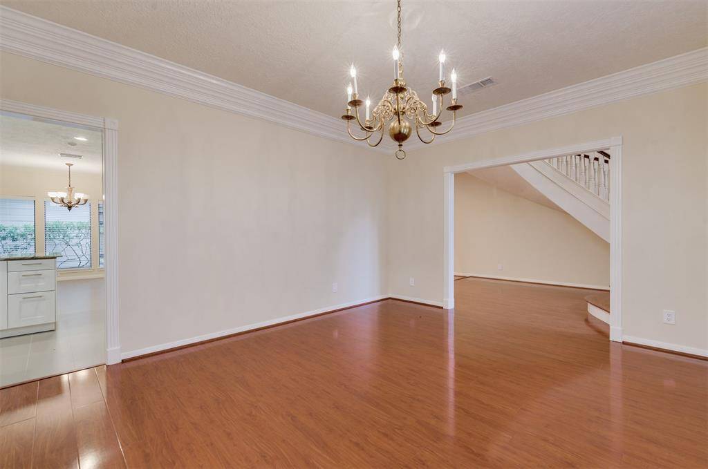 The formal dining room boasts double crown molding and hardwood floors.