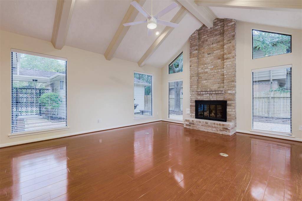 Originally built in the 1980's and now remodeled, the living room boasts soaring two story ceilings with wood beams and a floor to ceiling fireplace.