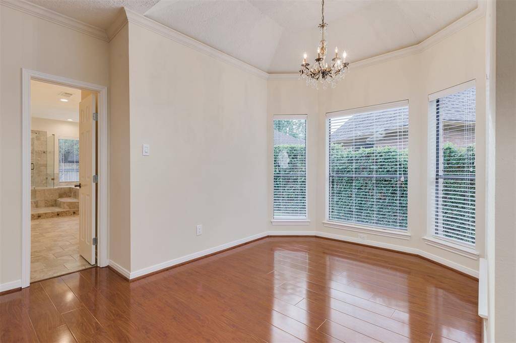 Sitting area off the master bedroom has garden windows overlooking greenery.