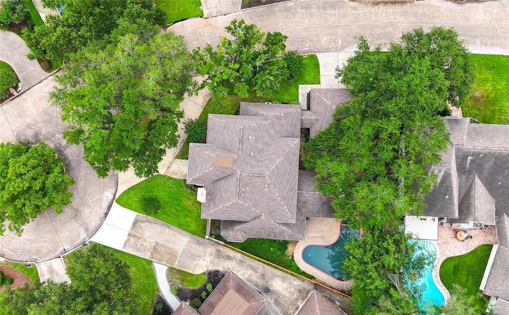 Impressive aerial view showcases the premium cul-de-sac location, expansive lot with a circular driveway, and a private backyard oasis complete with a sparkling pool—offering both curb appeal and resort-style living in the heart of Memorial Thicket.