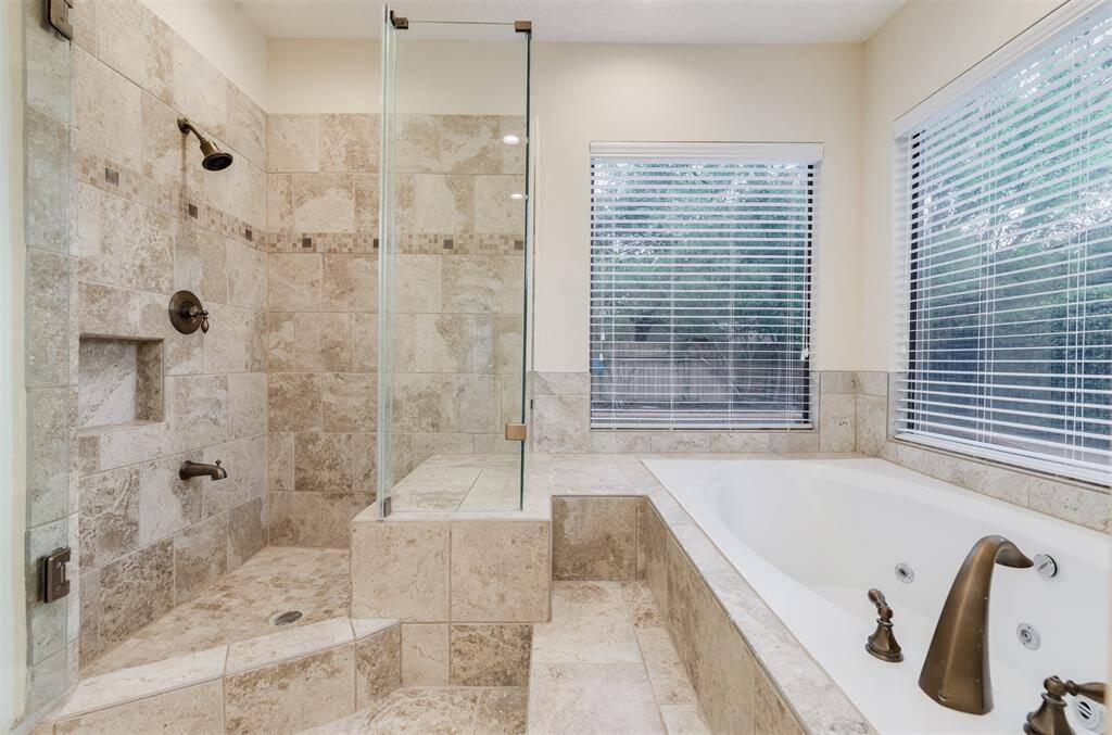 The master bathroom has a separate walk in shower with frameless shower doors and a separate Jacuzzi tub.