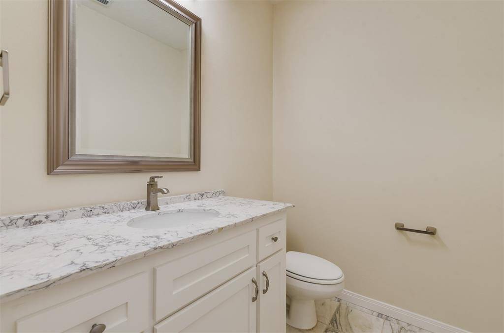 Downstairs powder room, or half bath is conveniently located off the living room for guest to use.  Beautifully updated with a granite top and marble floors.