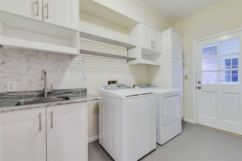 Downstairs laundry room is conveniently located off the kitchen and is equipped with lots of storage, a sink, and new washer and dryer.