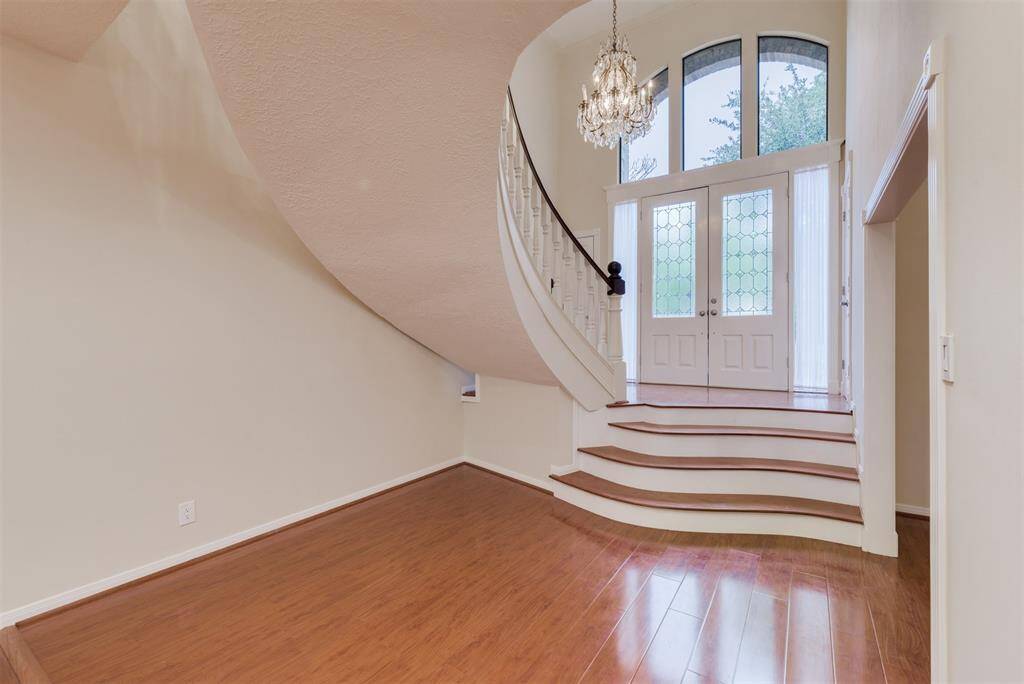 The interior of this custom home has been restored with Engineered hardwood floors throughout the entry and downstairs living rooms.  Elegant double door entry with crystal chandelier.