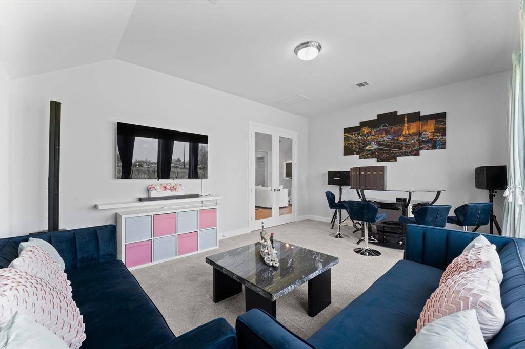 Another view of the game-room This is a modern living space  It has a bright and airy feel with high ceilings and a neutral color palette.