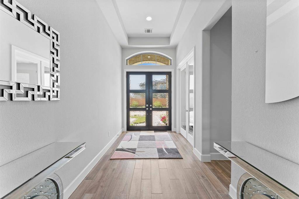 Another view of  the bright, contemporary entryway featuring high ceilings with a recessed light, enhancing the welcoming feel of the home.