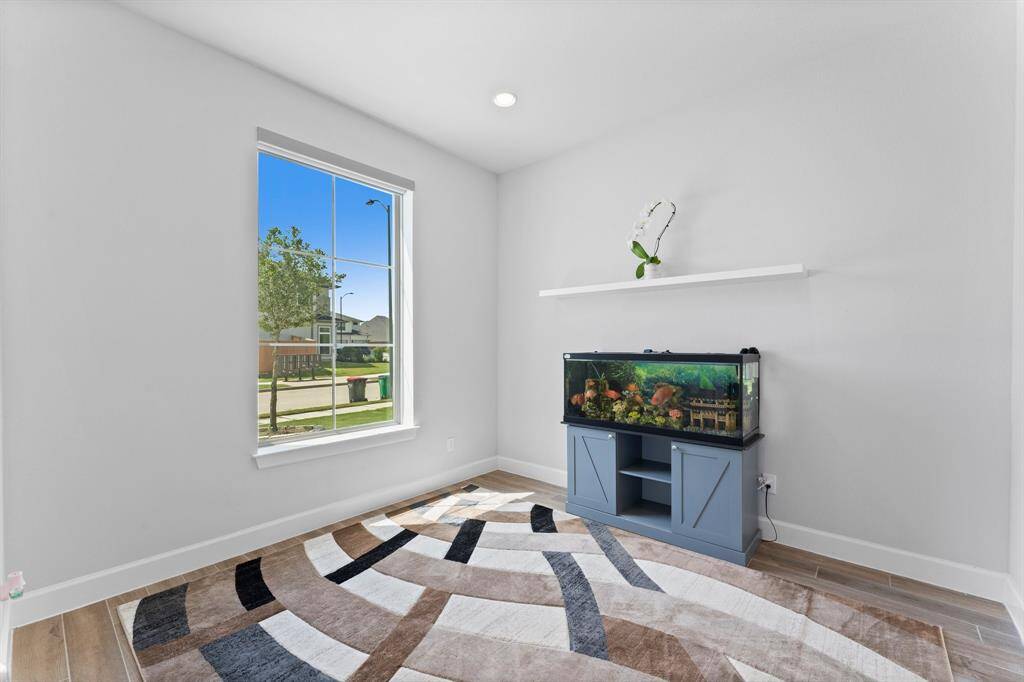 Home office w/French doors and a lofty 12' ceiling  a large window providing natural light, modern flooring, and a neutral color scheme. ready to add your personal touch.