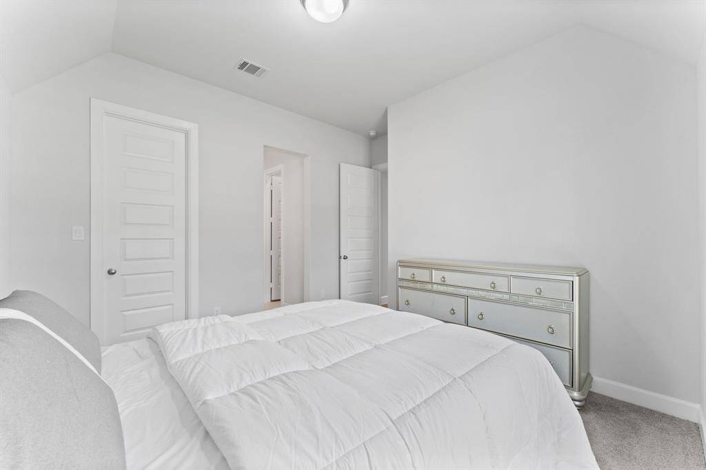 another bedroom with neutral colors, a plush clean  carpet.