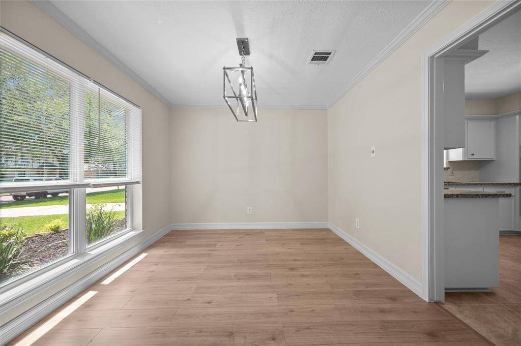 Front dining room with large windows, laminate floors and direct access to the kitchen.