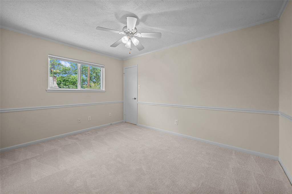 New carpet in spacious bedroom with neutral tones, ceiling fan, and large window.