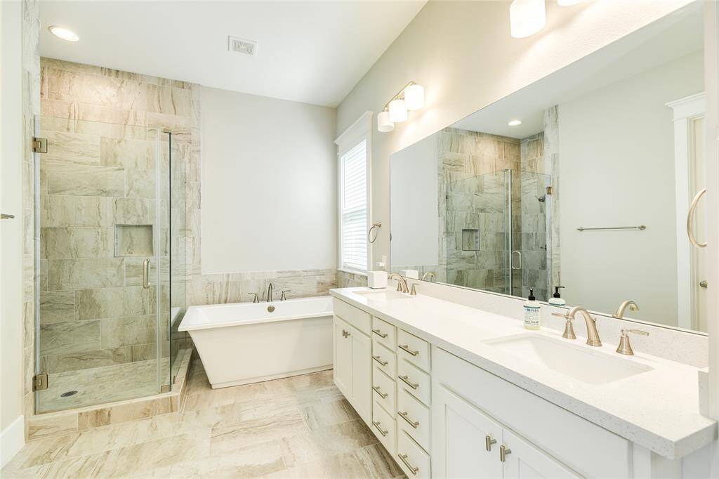 Large and luxurious, this primary bath features double sinks, lots of storage, a separate soaking tub and large walk-in shower and a water closet complete with bidet.