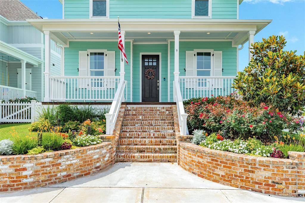 Lovely landscaping, landscape lighting, shutters, a deep porch, and a welcome home.