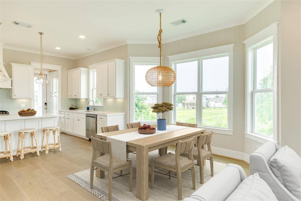 VIRTUALLY STAGED -  This dining area is large enough for a big table round, square, or rectangular and sits in front of a big bay window with loads of natural light and a designer light fixture.